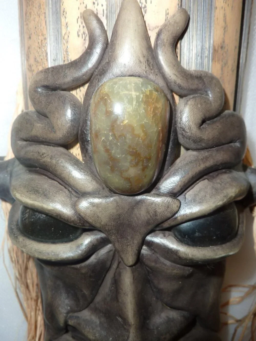 Clay mask on wood. Size 12 x 4 1/2 x 2 1/2 inches by artist Krisna Brasil